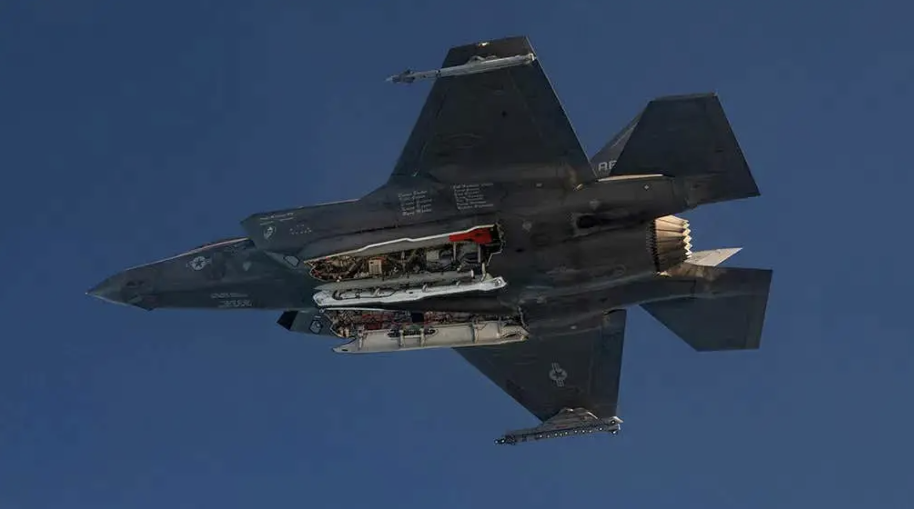 The red tail of an inert B61-12 is visible inside the bomb bay of this F-35A during a test flight. The jet also carries at least one AIM-120 AMRAAM air-to-air missile in its weapons bays. <em>U.S. Department of Defense</em>