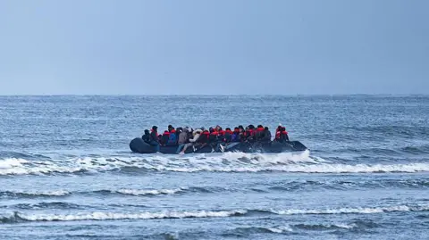 Government struggles to cut foreign aid spent on asylum hotels Getty Images A boat in the English Channel with people on it, many wearing orange life jackets.