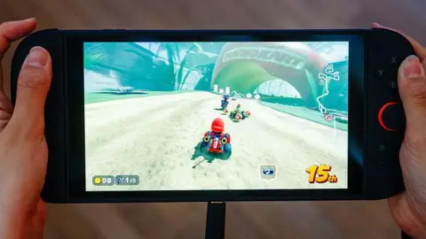 Stores open at midnight as fans rush to buy Nintendo Switch 2 Getty Images A person playing Mario Kart World on a Switch 2 console
