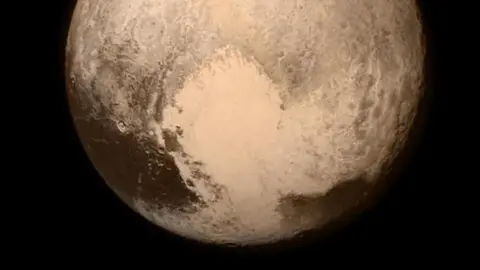 Trump-Musk row fuels 'biggest crisis ever' at Nasa NASA/Johns Hopkins The planet Pluto appears as a sandy brown in the blackness of space with what appears to be a light coloured heart shape appearing in the southern hemisphere
