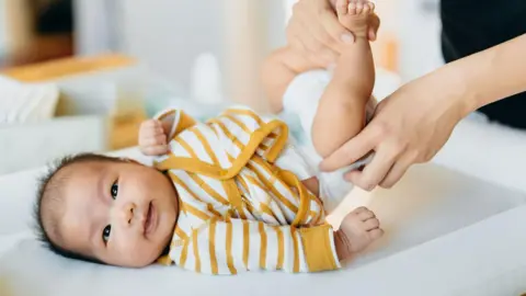 First bacteria we meet can keep us out of hospital Getty Images Baby in yellow/white striped vest smiling through a nappy change