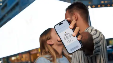 Why it has one of the most digital governments Ministry of Digital Transformation Ukraine A couple appear to be kissing but one blocks the view with a phone showing the Diia app