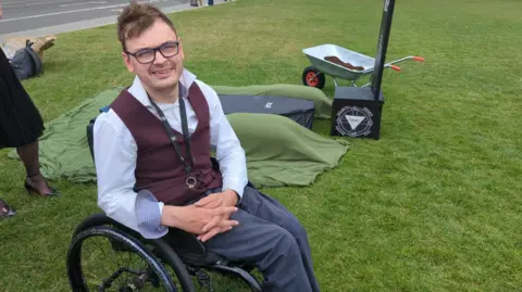 MPs back assisted dying bill in historic Commons vote George Fielding next to a mock grave