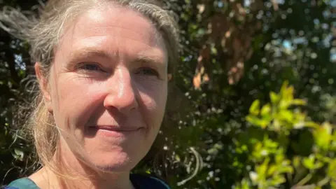 Hopes to open NHS ketamine clinic for treatment resistant depression Dr Ross looks at the camera. She is outside with a background of greenery.