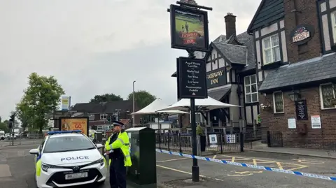 Teens arrested on suspicion of murder as boy, 14, stabbed to death BBC Police officer stands by a police car in front of a police cordon around the Fairway Inn in New Moston following the death of a boy.