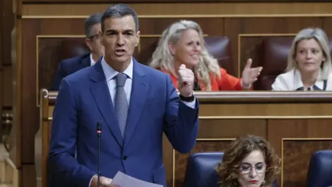 Leaders arrive at Hague summit as Nato chief Rutte flatters Trump EPA A man in a blue suit speaks in the Spanish parliament raising his left hand