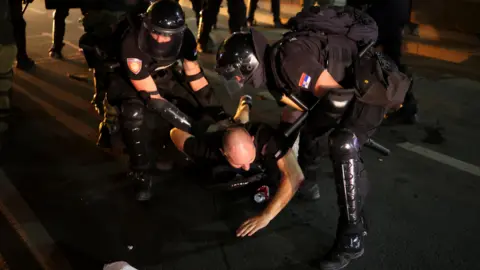 Serbia police clash with protesters calling for early election Reuters Law enforcement officers detain a demonstrator, during an anti-government protest demanding snap elections, in Belgrade