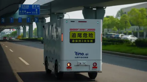 China's driverless lorries hope to expand BBC/Joyce Liu A Rino AI delivery truck cruises on the road in China