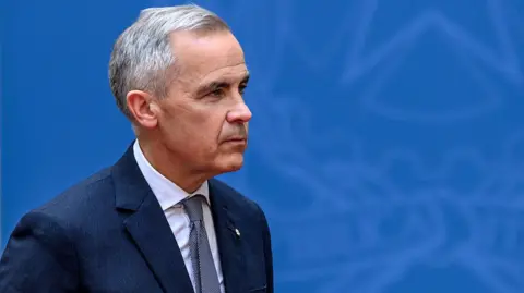 G7 is a big moment for Carney. Here are five things to watch Getty Images Canadian Prime Minister Mark Carney seen against a blue backdrop, wearing a darker blue suit and tie. He has a neutral expression