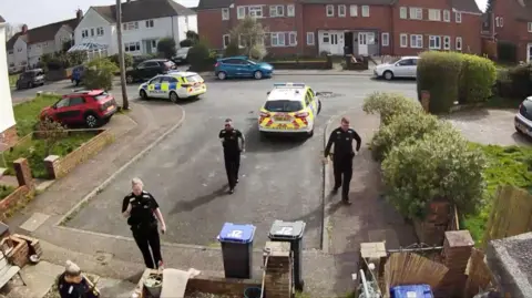 A neighbour threatened dad with a knife Supplied A group of police officers stand in front of a house