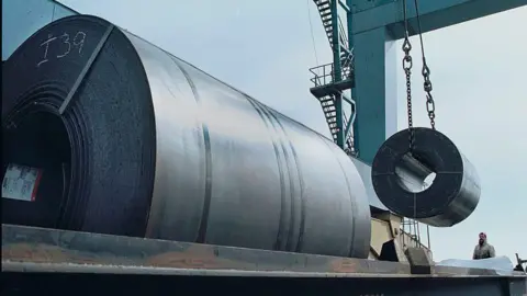 Donald Trump doubles US steel and aluminium tariffs to 50% Getty Images Workers use a crane to load a 60,000 pound coil of steel from Holland onto a railroad car for shipment to Ford Motor Company in Ohio from a warehouse at the South Jersey Port Corporation, March 6, 2002 in Camden, NJ along the Delaware River.