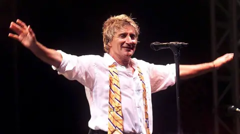 'I wish they wouldn't call it the tea time slot' Carl De Souza/Shutterstock Rod Stewart stretches out his arms to greet the Glastonbury crowd during a performance in 2002