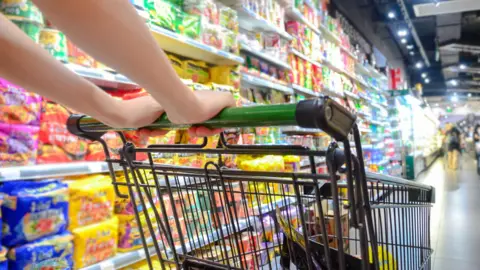 Food makes up majority of NI household spending Getty Images A woman pushes a shopping cart to choose products in a supermarket.