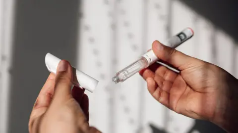 Mounjaro weight loss jab available at GPs Getty Images White injector pen with clear fluid in, held in two hands against a white background with shadows