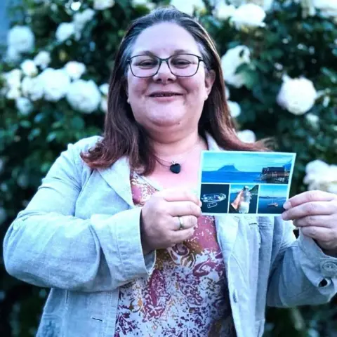 Moray schoolgirl's message in a bottle gets reply from Norway 31 years later Aileen Stephen Woman - Alaina Beresford - smiling at camera and holding a postcard, which shows a message in a bottle she sent 31 years ago, after it was found.