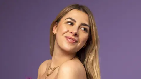'It doesn't matter that my boyfriend is 5ft 6in"' A young women with blonde hair, wearing gold jewellery.