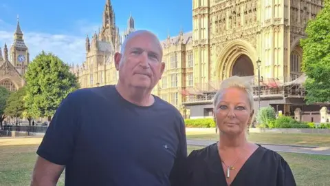 Foreign Office faces inquiry over its handling of Harry Dunn case PA Media Radd Seigar with very short white hair wearing a black T-shirt and Charlotte Charles with medium-length white hair wearing long drop earrings, a silver necklace and a black dress. They are standing outside the House of Commons.