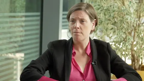 Is surveillance culture fuelling child cyberstalking? Safeguarding minister, Jess Phillips MP wears a pink shirt and black blazer.