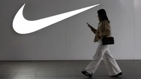 Nike says US trade policies could cost it $1bn EPA-EFE/REX/Shutterstock A woman walks past a Nike store in Beijing, China, 8 April 2025.