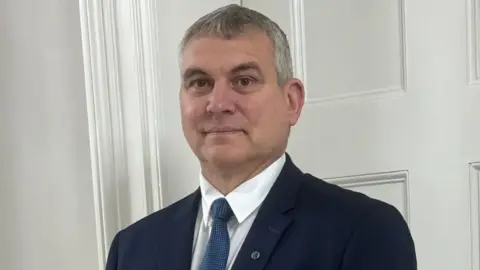Poundland founder would have bought business back Steven Smith A headshot of a man with grey hair wearing a navy suit, white shirt and blue tie smiling into the camera. He is standing in front of a white wall. He has a small badge on his lapel.