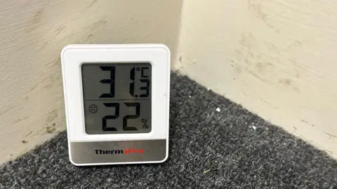 'It was sold as a dream but became a nightmare' A thermometer showing that the corridor in Fatima's corridor was 31C (88F)