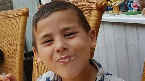 Child abuse training failures before Alfie Steele's Droitwich murder Family Handout A boy sits on a wicker chair outside and smiles at the camera. He has dak brown hair and he is eating ice cream.
