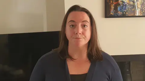 'I paid £15,000 then it went bust' Beth Rodgers Beth Rodgers, a 32-year-old woman. She is standing in her living room wearing a navy cardigan and black top.