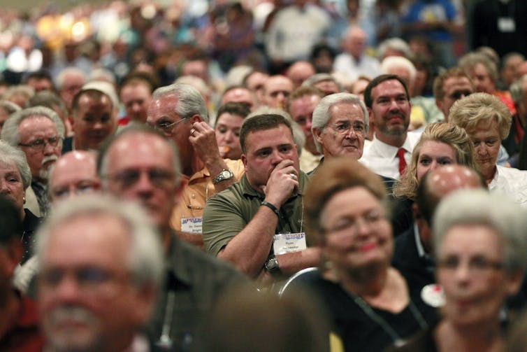 Southern Baptists’ call for the US Supreme Court to overturn its same-sex marriage decision is part of a long history of opposing women’s and LGBTQ+ people’s rights Close-up of several seated individuals looking ahead while listening to a speaker, with a few seen smiling.