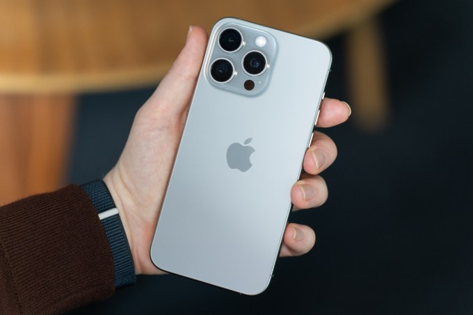 Apple Intelligence: Everything you need to know about Apple's AI model and services iPhone 15 Pro Max in natural titanium, being held, showing the back of the phone