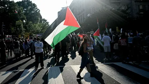Trump upbeat on Gaza ceasefire talks as he hosts Netanyahu Getty Images Protesters wave Palestinian flags during Benjamin Netanyahu's visit with Donald Trump in Washington DC on 7 July 2025.
