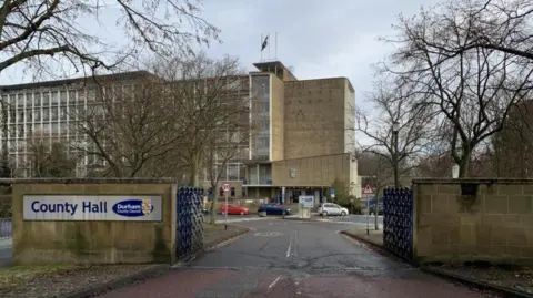 Durham County Council proposes capping council tax support BBC An outside view of Durham County Hall from outside the gates. Cars can be seen parked outside the large grey building.
