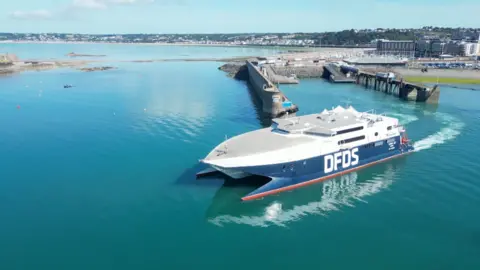 'Perfect storm' causes downfall in Jersey visitors BBC A DFDS ferry departs St Helier in Jersey on a sunny day. The water appears to be still.