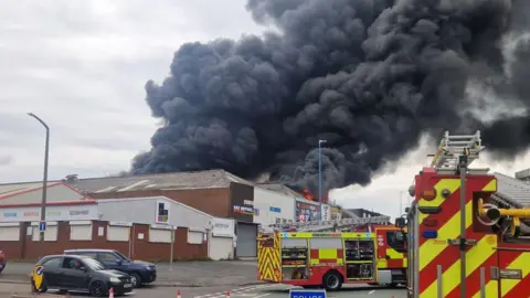 Homes evacuated as factories and tyres burn near Tipton Melvin Cooper A factory fire has sent great plumes of smoke into the air. Two fire appliances can be seen outside it.