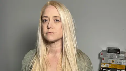 Surgeon banned by private practice is working for NHS Sheryl Hunter, a middle aged woman with long blonde hair, looks directly into the camera. She wears a green/grey cardigan.