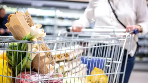 Food prices remain 'stubbornly high' in Northern Ireland as inflation rate rises Getty Images A woman is pushing a shopping trolley in a supermarket. Eggs and vegetables are in the trolley.