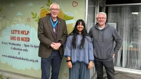 Weston woman wins British Citizen Award for creating food bank Aishah Ahmed Aishah Ahmed with two men standing in front of her distribution site for her charity. She has long black hair and a blue jumper on