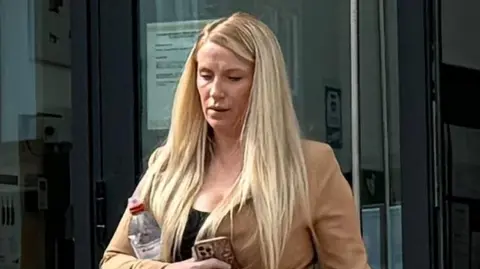 Woman who let child drive car in Crimond must do unpaid work BBC A woman with long blonde hair tied up in a ponytail walks out of court looking down. She wears a black top with a beige jacket. She has a water bottle tucked under her arm and is holding an iPhone.