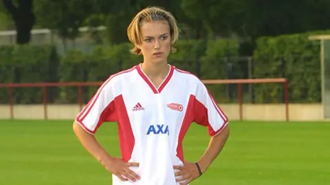 Bend It Like Beckham sequel in the works, director tells BBC Sygma via Getty Images Keira Knightley during the filming of Bend It Like Beckham, standing on a grass pitch. She stands with her hands on her hips and wears a white-and-red football strip. Her hair is pulled back with an alice band.