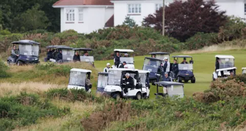 Security tightens as Donald Trump plays golf at Turnberry PA Media Donald Trump leading a convoy of 15 other golf buggies