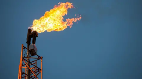 Jeff Bezos-backed $88m methane satellite missing in space Karol Serewis/Getty Images An orange tower on the left of the picture, a orange flame is being emitted with black smoke trailing left to right. The tower stands against a blue sky. The flame is produced by flaring from oil production