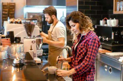 How to get one when you have zero work experience Getty Images A young woman with long wavy hair and a red checked shirt is decorating a cup of cappuccino. A young bearded male barista, wearing a beige apron and grey t-shirt, is working in the background amidst steam rising from an espresso machine. The café has a sleek black-tiled wall and modern coffee-making equipment, creating a warm and inviting workspace atmosphere.