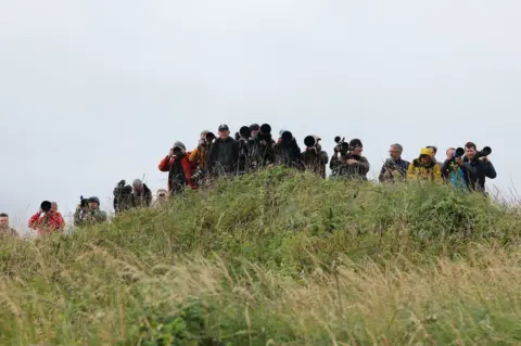 Security tightens as Donald Trump plays golf at Turnberry Reuters Journalists and photographers on a grassy hill at Turnberry