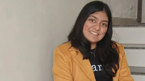 'I'm being paid to fix issues caused by AI' Kashish Barot Smiling Kashish Barot in a suede-coloured jacket