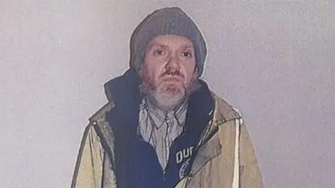 Man found guilty of murder of Anita Rose in Brantham in 2024 Crown Prosecution Service Roy Barclay in a yellow hi-vis jacket that finishes mid-thigh. He is also wearing a grey beanie, a stripy shirt, and a dark fleece zipped up