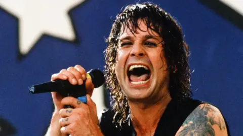 Getty Images A picture of a younger Ozzy Osbourne singing into a microphone
