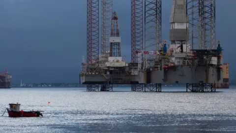 North Sea operators 'running out of time' to plug old oil wells Getty Images A line of rigs stacked up in the water with two small boats in the foreground and a sky of dark clouds