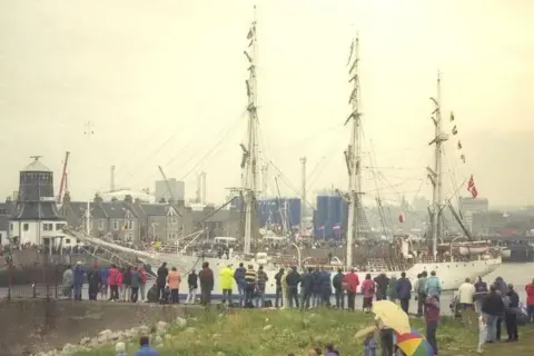 'Party city' event gets under sail Aberdeen City Council White tall ship with three masts, with Aberdeen in the background and spectators in the foreground.