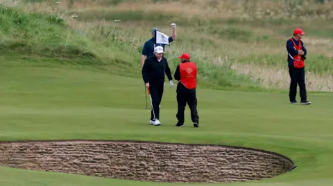 Trump back on the golf course for day two of Scottish visit Reuters Two golfers and two caddies on a green