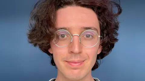 Bangor Cathedral had 'binge drinking culture' at diocese Esme Byrd A picture of a person's face with brown wavy hair and circular glasses in front of a blue background