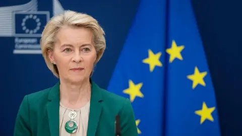 EU delays retaliatory trade tariffs against US Getty Images European Commission President Ursula von der Leyen sitting in front of the EU flag
